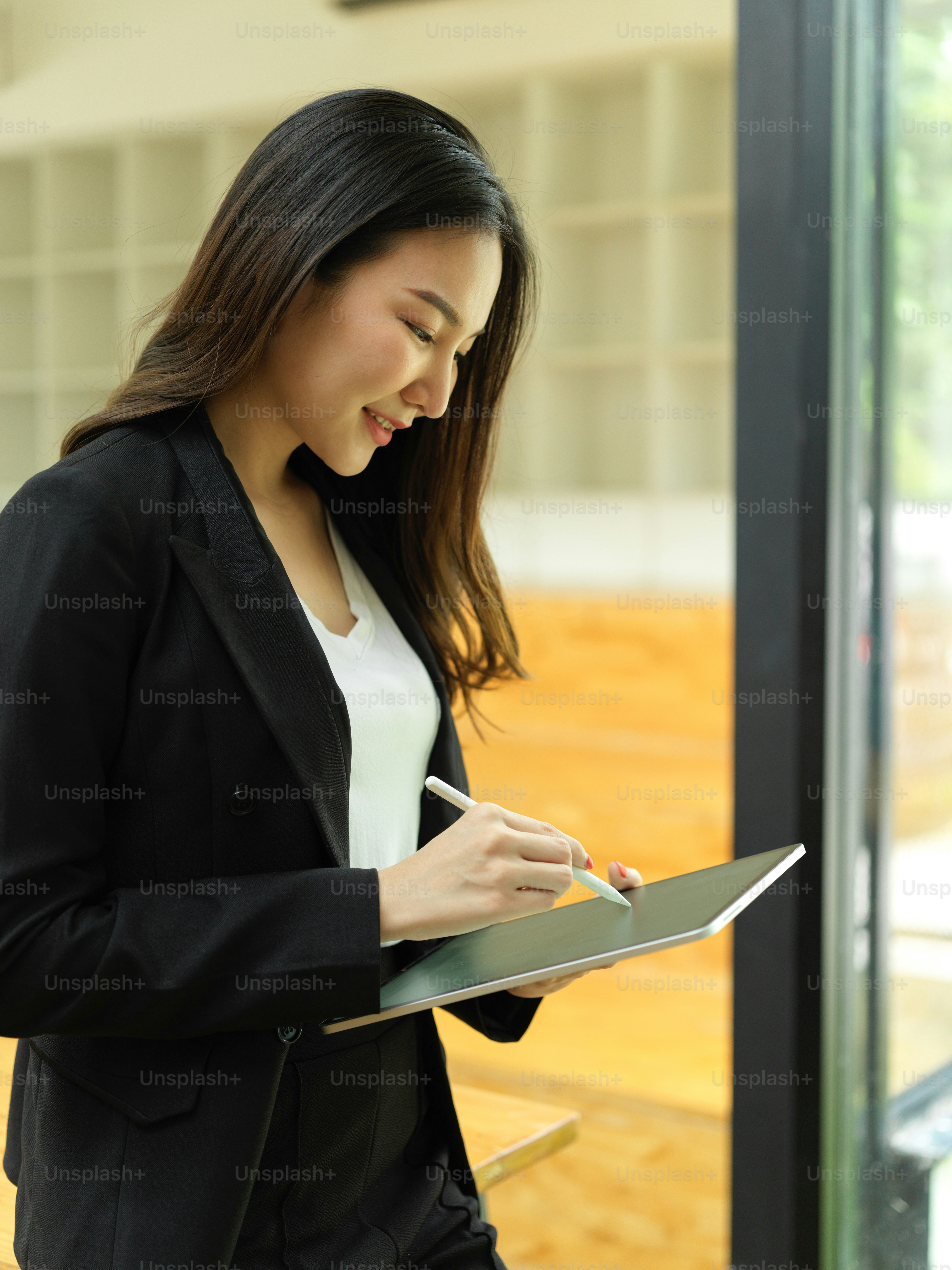 Retrato de vista lateral de una mujer de negocios usando una tableta digital mientras camina en el edificio de oficinas