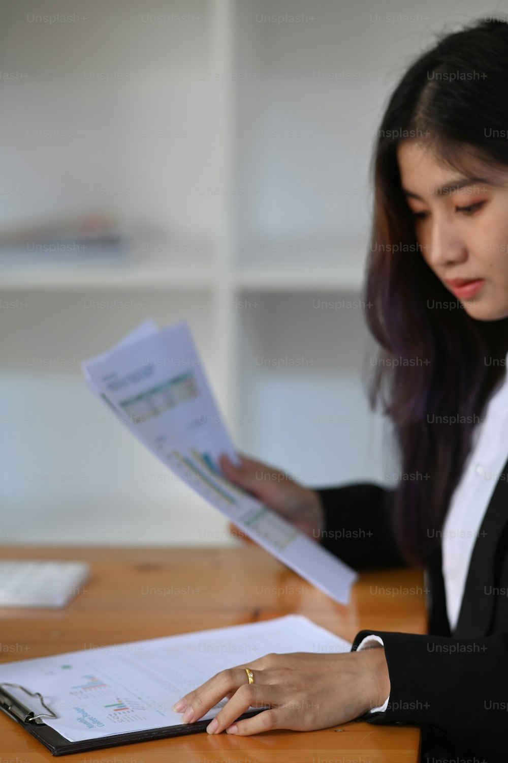 Businesswoman checking financial report in office.