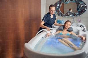 スパサロンでのハイドロマッサージ中に浴槽に横たわる患者の正面図