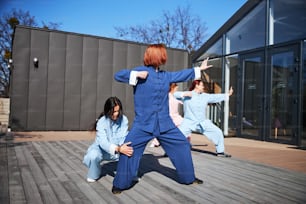 Group of women practicing traditional Chinese martial arts and their master correcting body postures