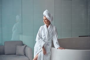 Jolie jeune femme moderne avec ses cheveux enveloppés dans une serviette de bain dans un centre de spa