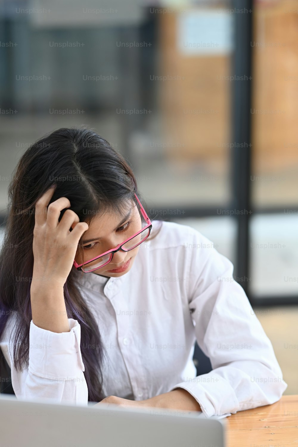 Femme d’affaires qui s’ennuie assise à un bureau devant un ordinateur portable.