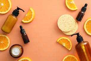 Cosmética cítrica natural de capa plana con rodajas de naranja. Vista superior de los productos de belleza orgánicos SPA.
