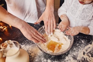 Close up view of brother with his little sister that preparing food on kitchen and have fun.