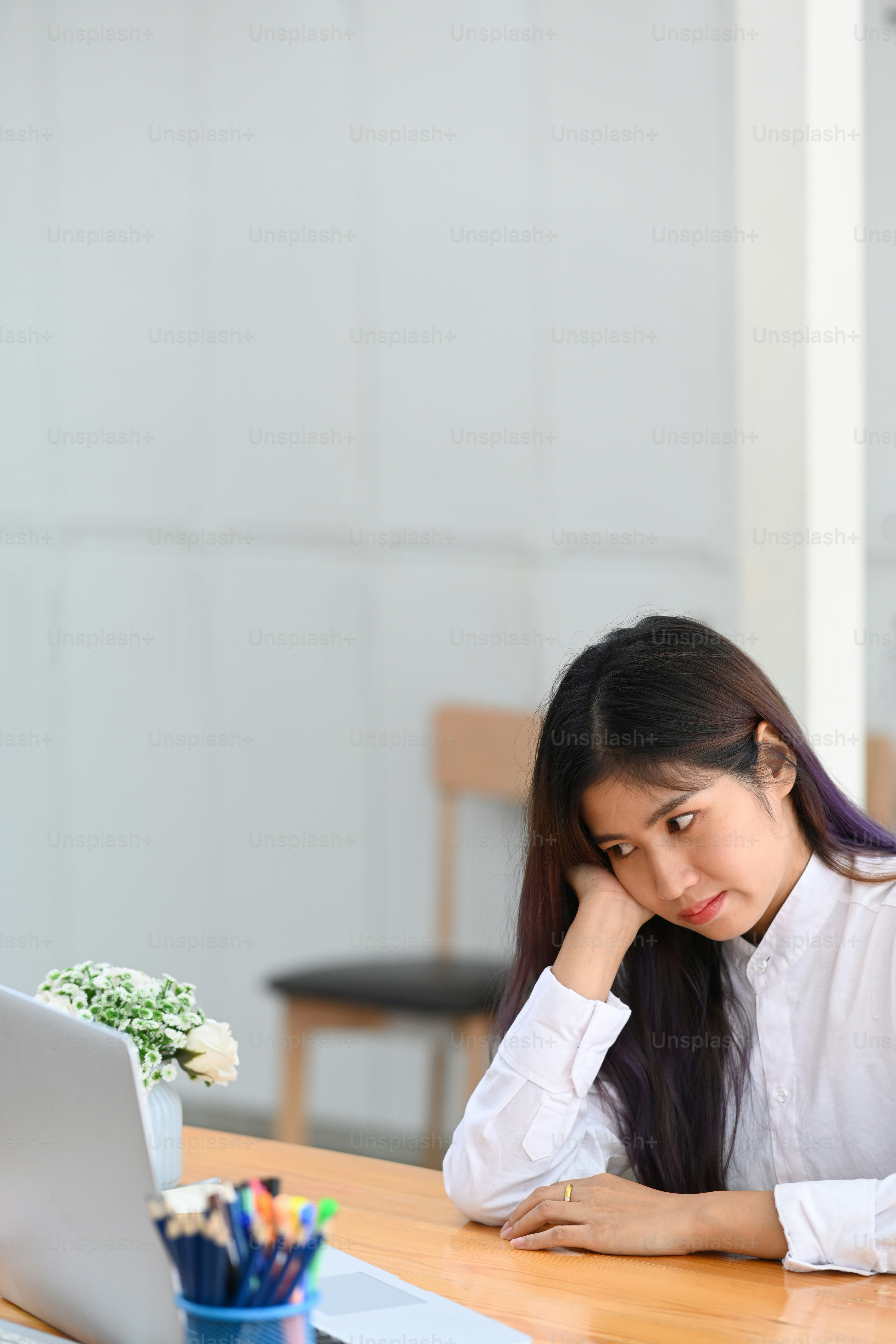 Donna d'affari annoiata seduta sul suo posto di lavoro.