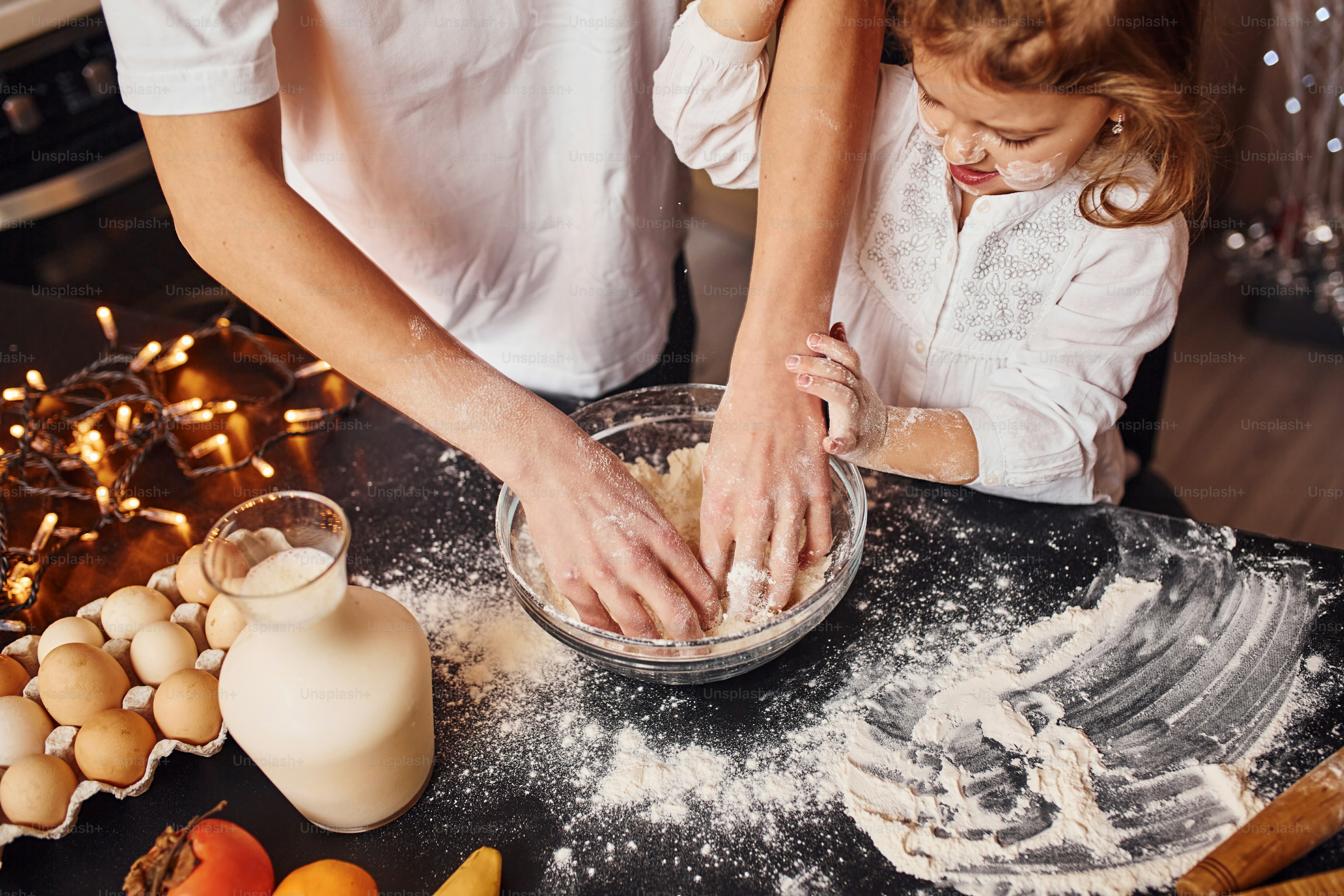 Close up view of brother with his little sister that preparing food on kitchen and have fun.