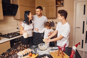 Happy family have fun on the kitchen and preparing food.