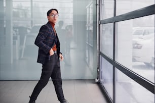 Young business man in luxury suit and formal clothes is indoors in the office.