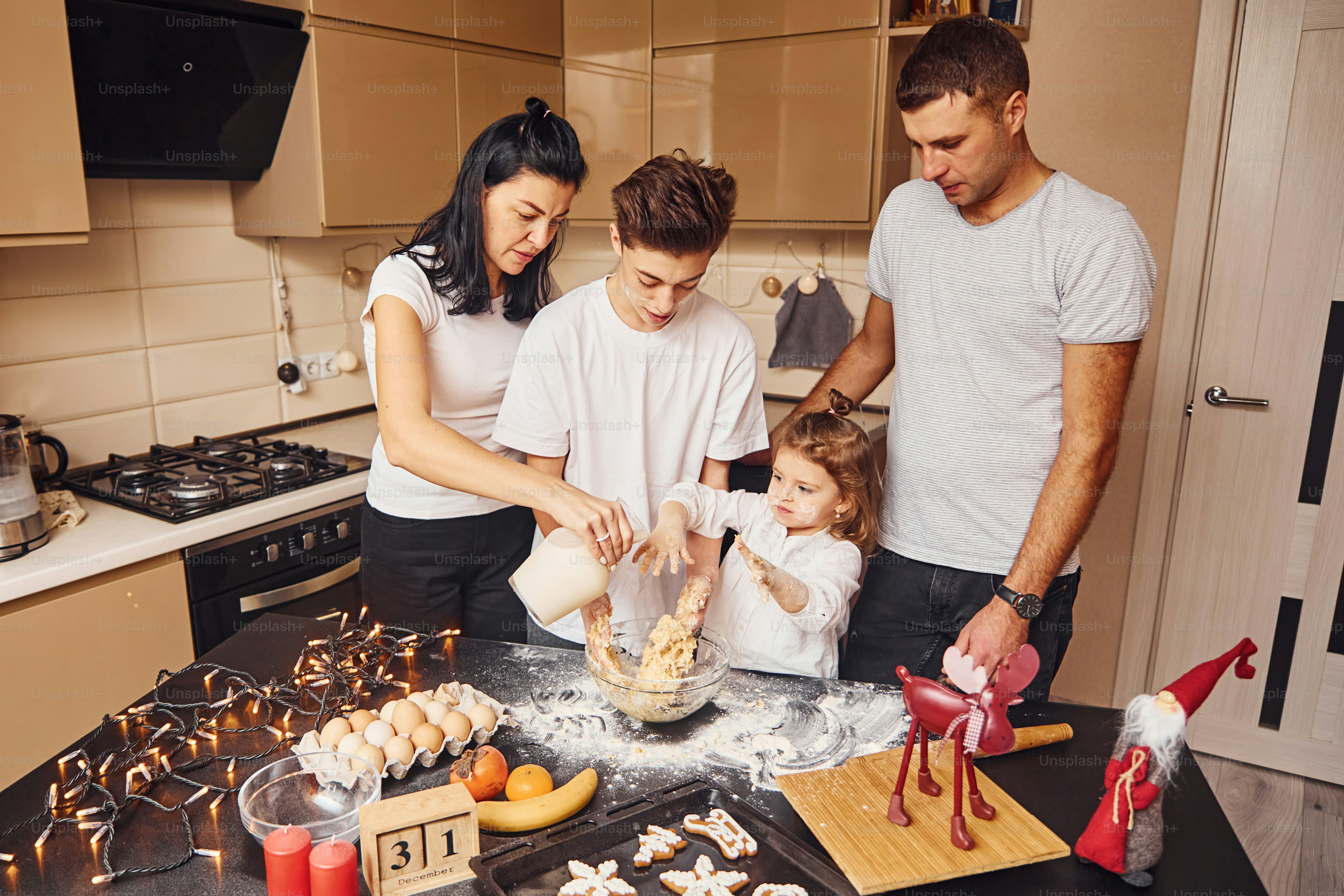 La familia feliz se divierte en la cocina y preparando la comida. foto ...