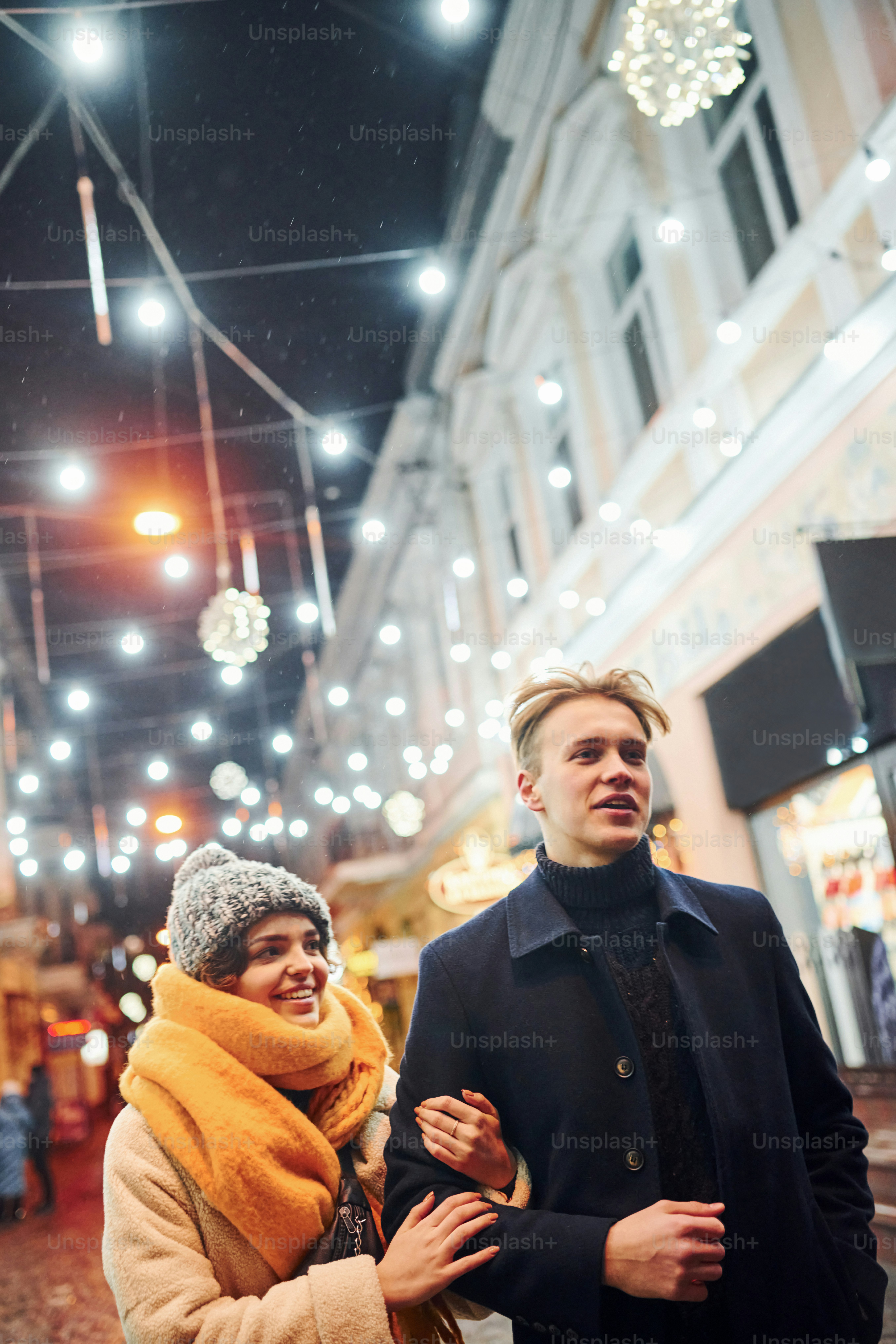 Couple have a walk together on the christmas decorated street.
