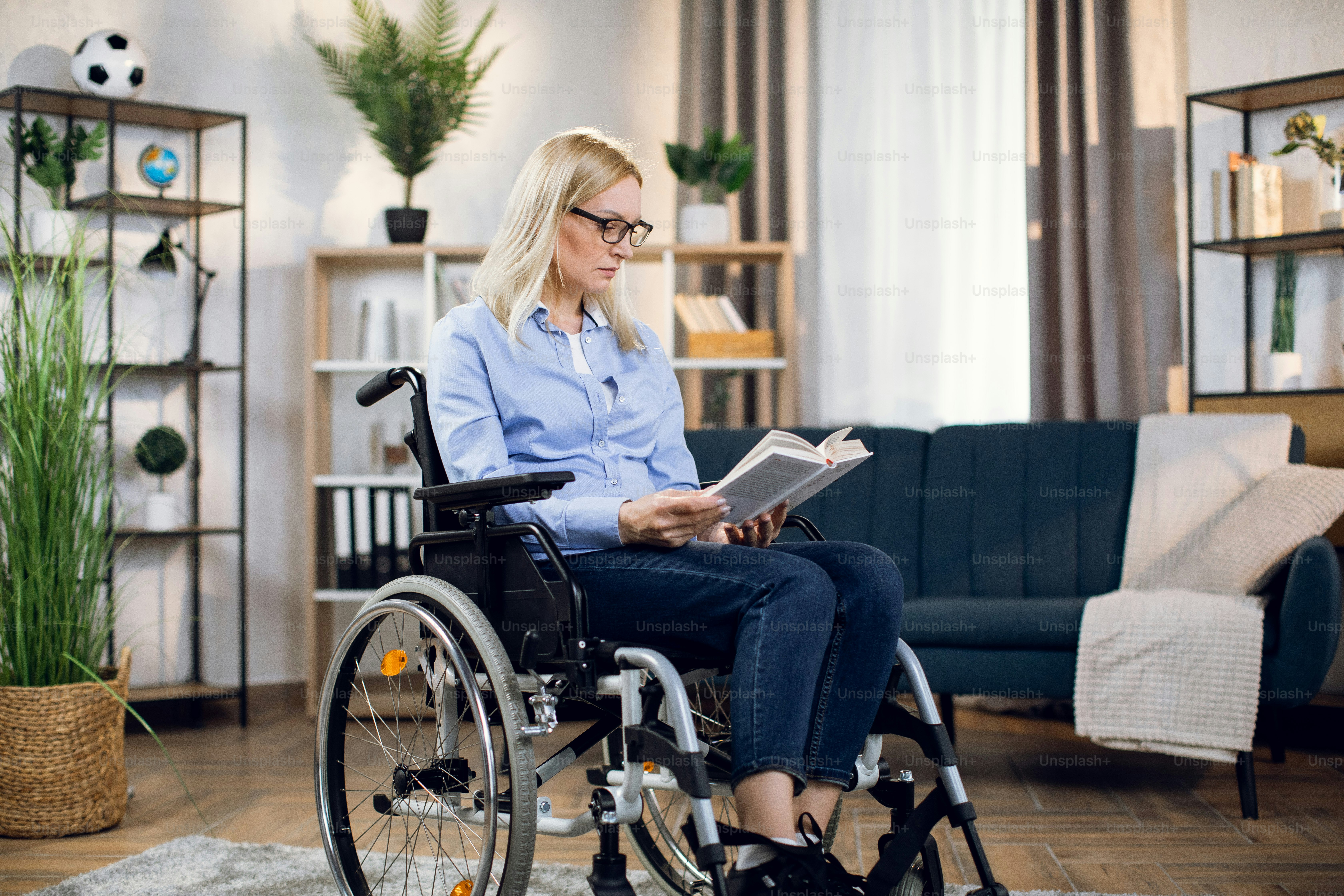 Pretty young woman with special needs reading book while staying at ...
