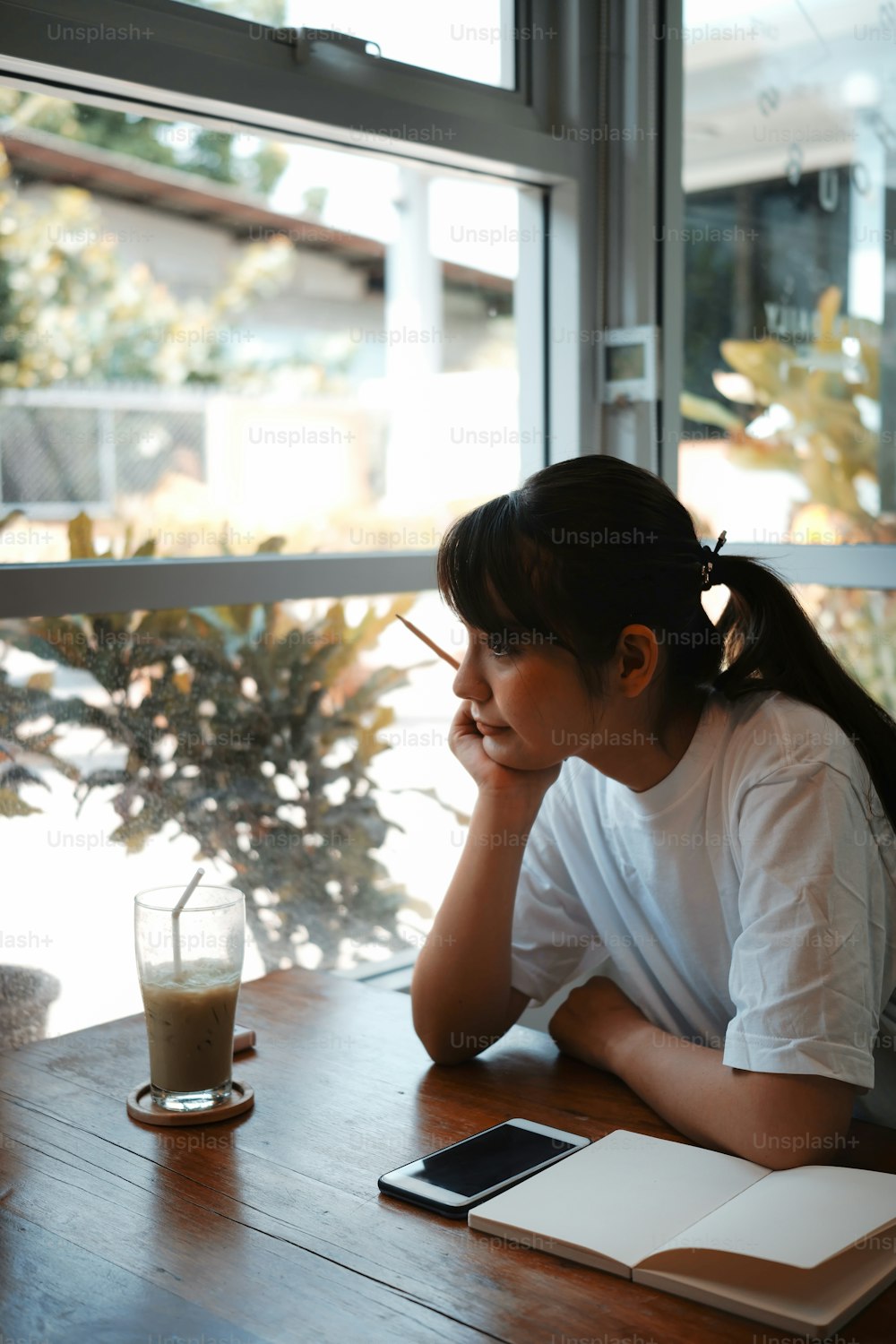 Portrait of peaceful young woman looking through the window.