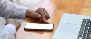 Cropped shot woman using smart phone on her office desk.