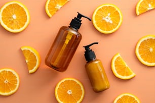 Composição de flat lay com frascos cosméticos SPA e fatias de laranja no fundo colorido.