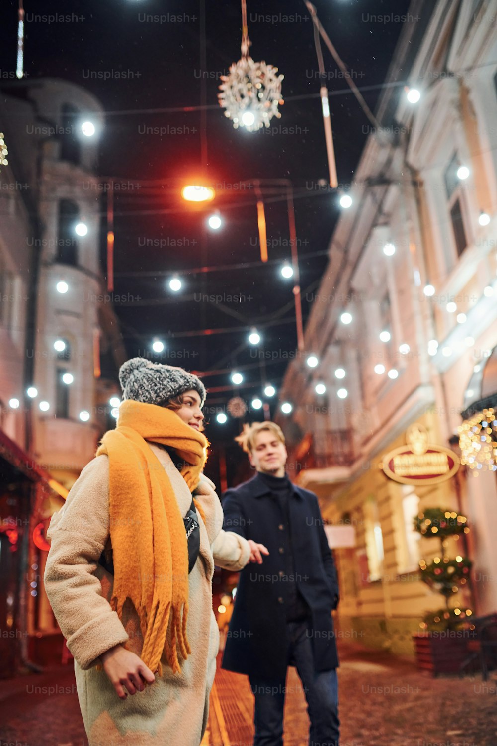 Couple have a walk together on the christmas decorated street.