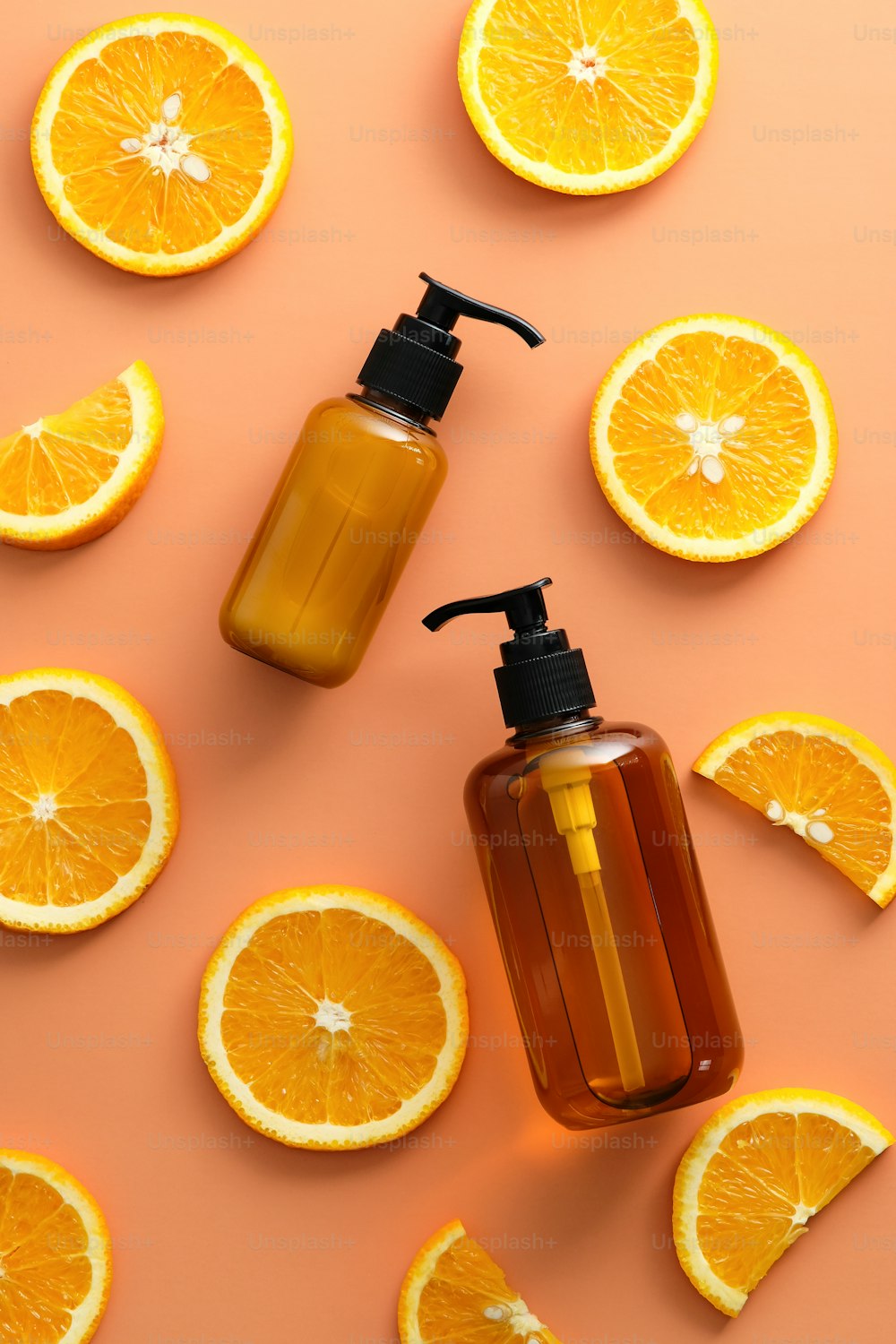 Vitamin C SPA cosmetics set. Flat lay, top view amber glass bottles and orange slices on color background.