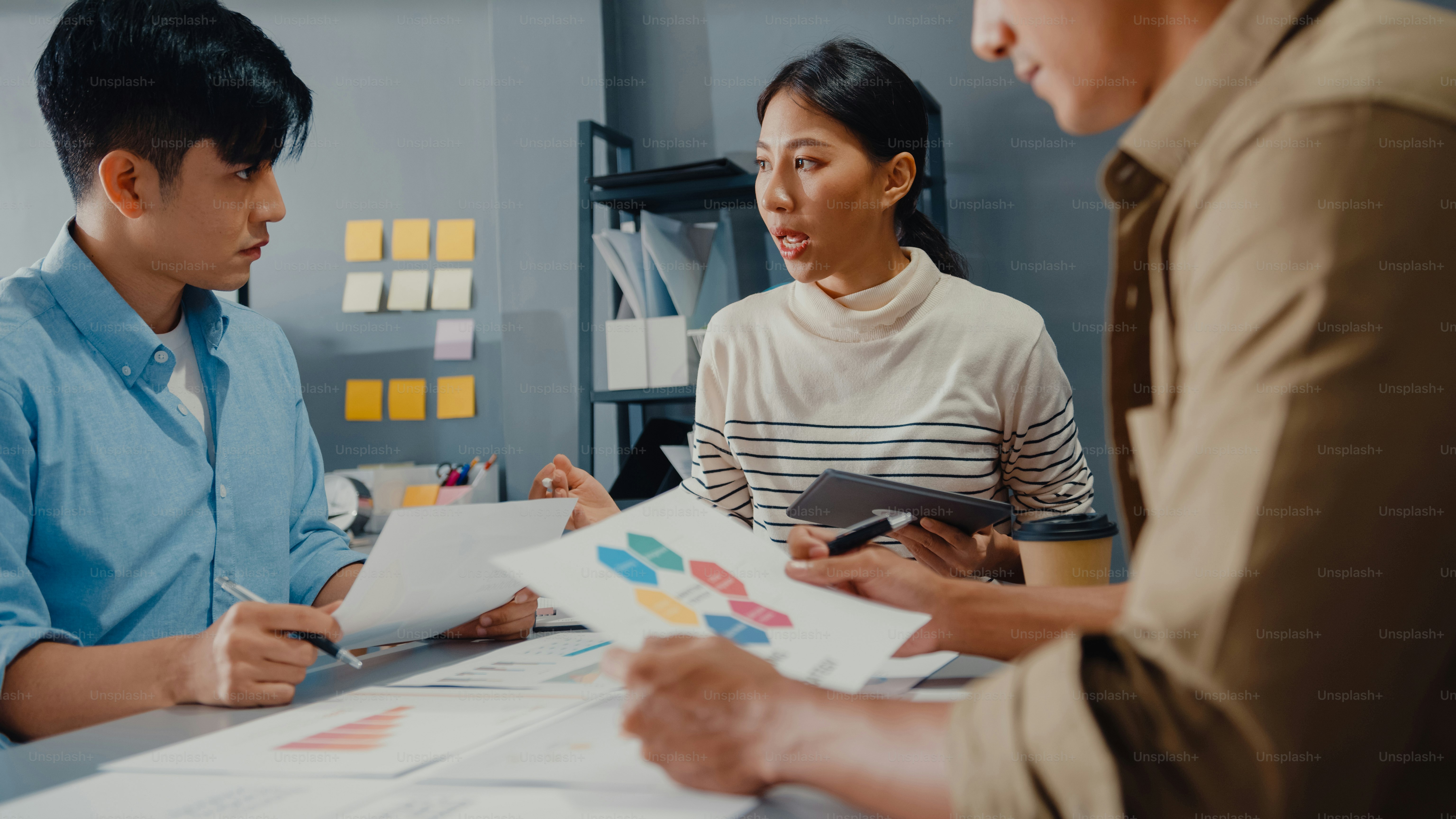 Happy young Asia businessmen and businesswomen meeting brainstorming some new ideas about project to his partner working together planning success strategy enjoy teamwork in small modern home office.