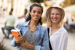 Two woman on the street carrying books.