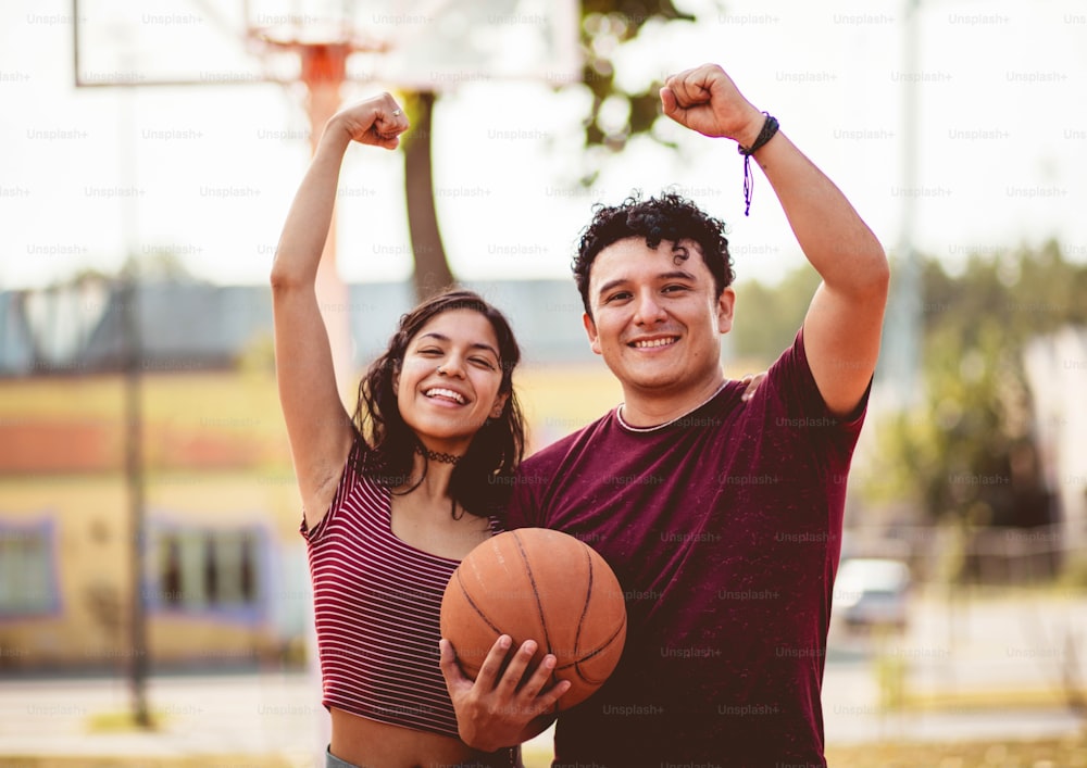 Jovem casal jogando basquete.