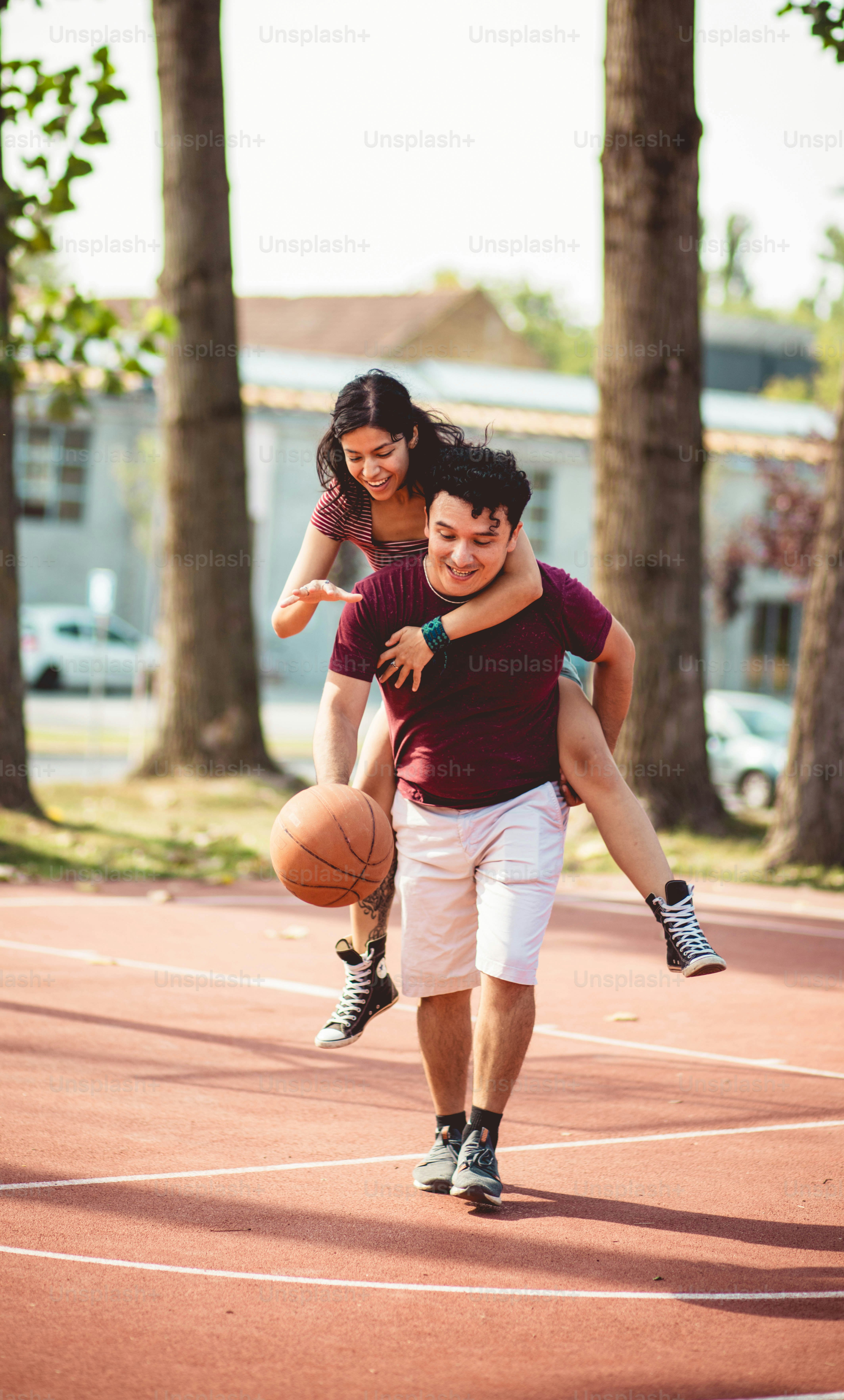 Jeune couple jouant au basket-ball.