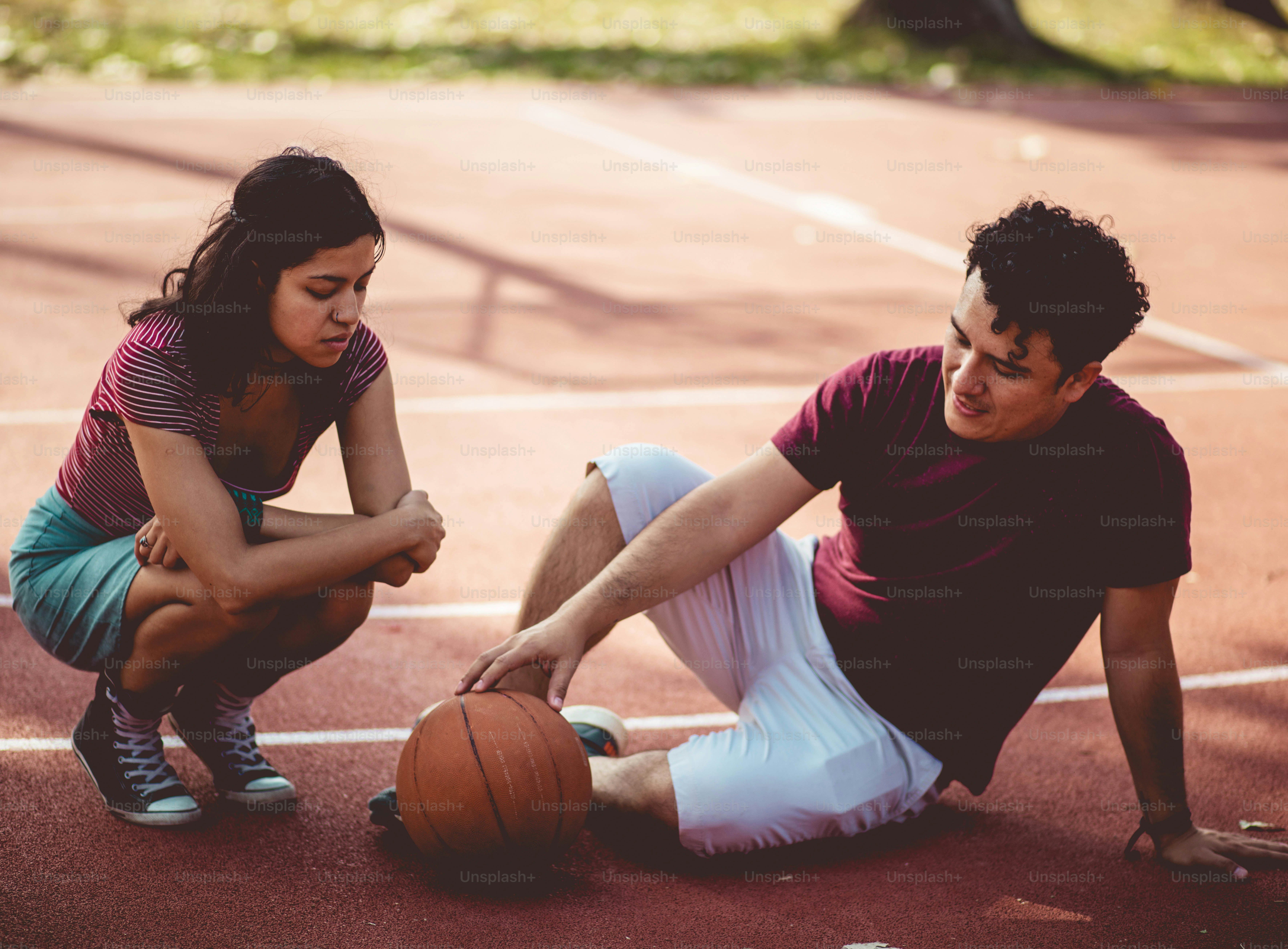 Couple sur un terrain de basket. Homme blessé.