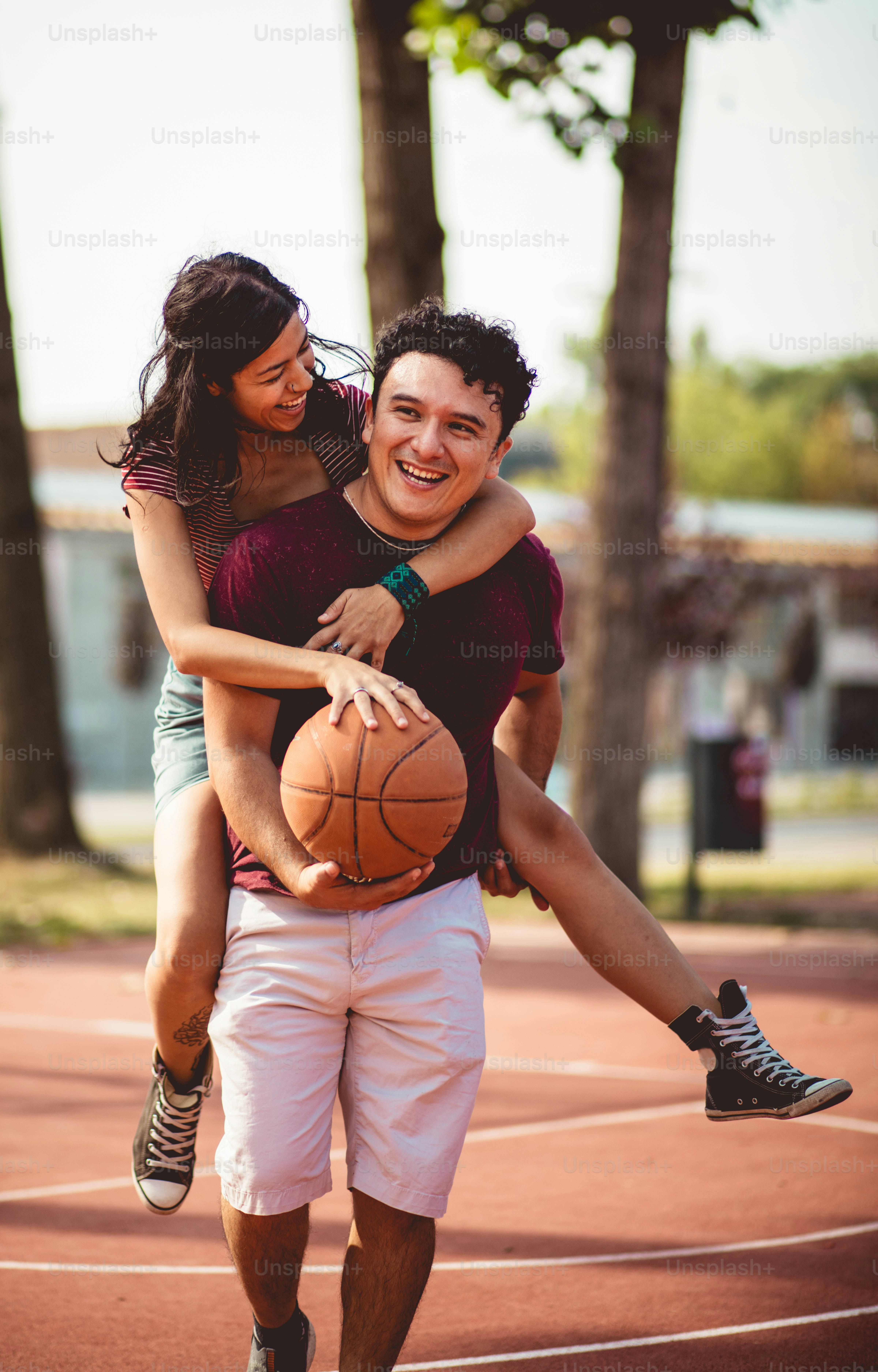Jeune couple jouant au basket-ball.