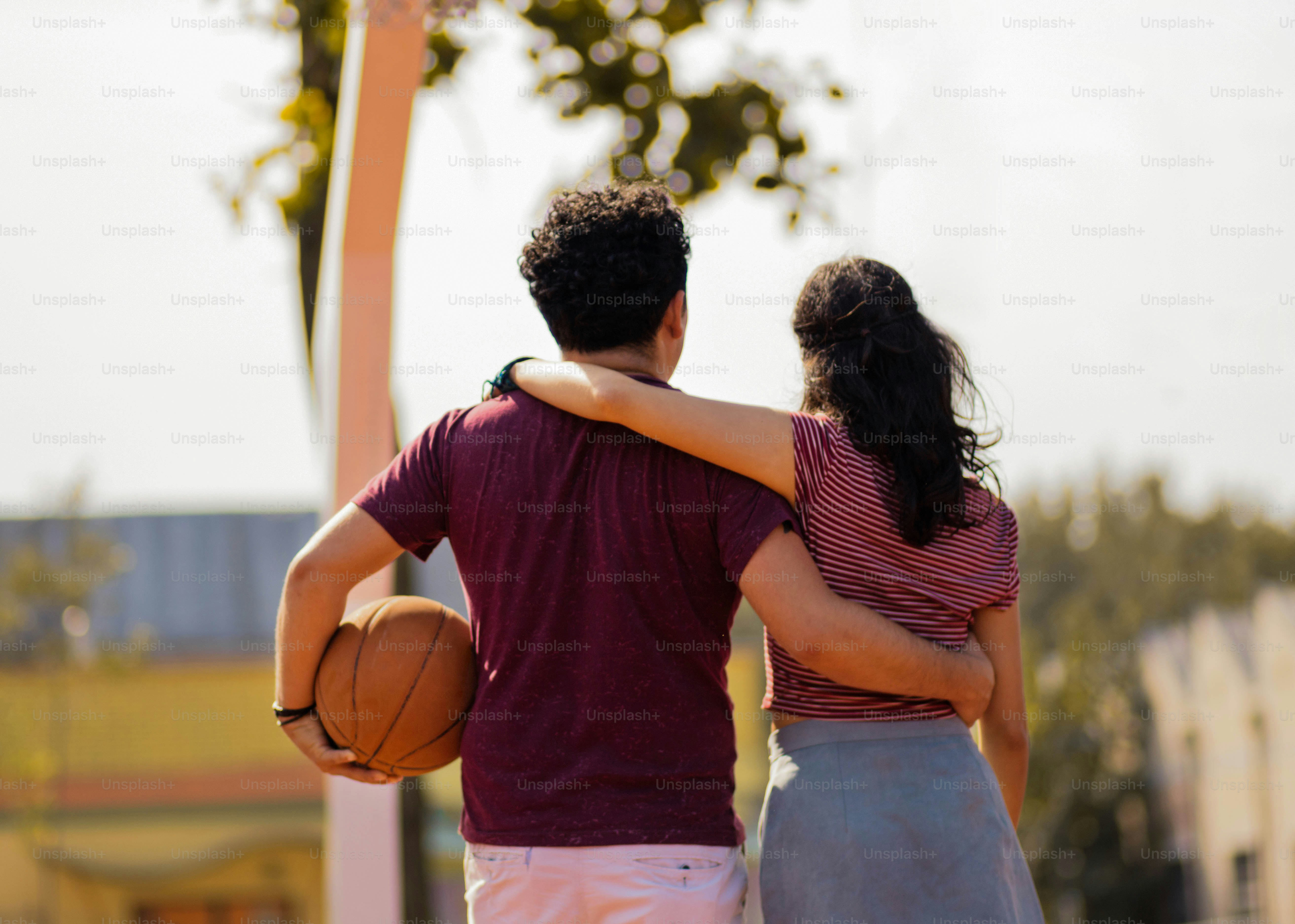 Couple avec ballon sur le terrain de basket-ball.
