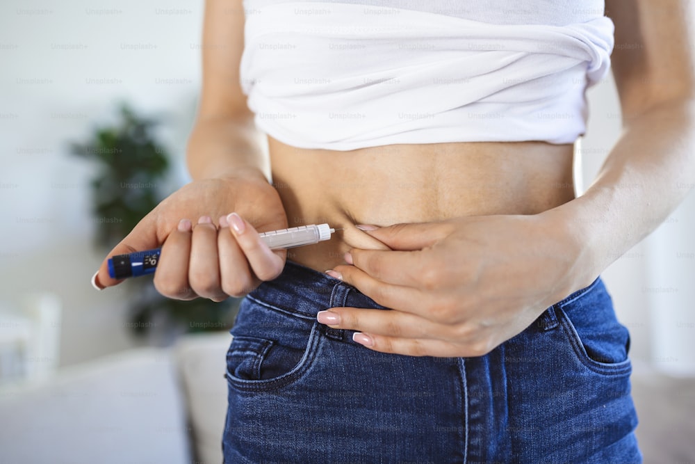 집에서 인슐린 주사를 하기 위해 인슐린 펜을 사용하는 당뇨병 환자. 젊은 여자는 당뇨병을 통제합니다. 당뇨병 생활 방식