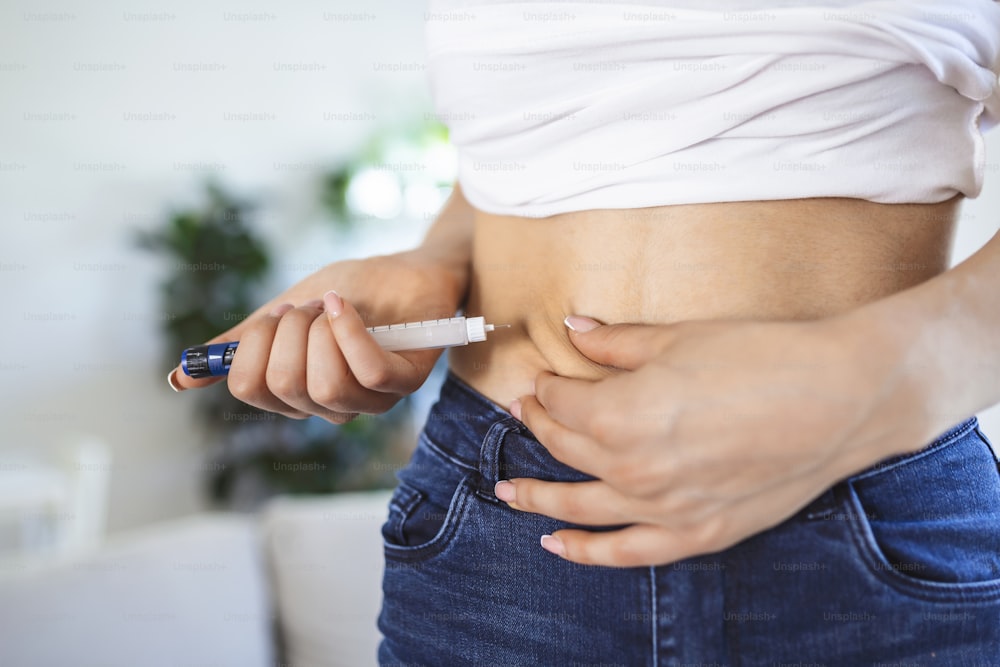 自宅でインスリン注射をするためにインスリンペンを使用している糖尿病患者。若い女性は糖尿病をコントロールします。糖尿病のライフスタイル