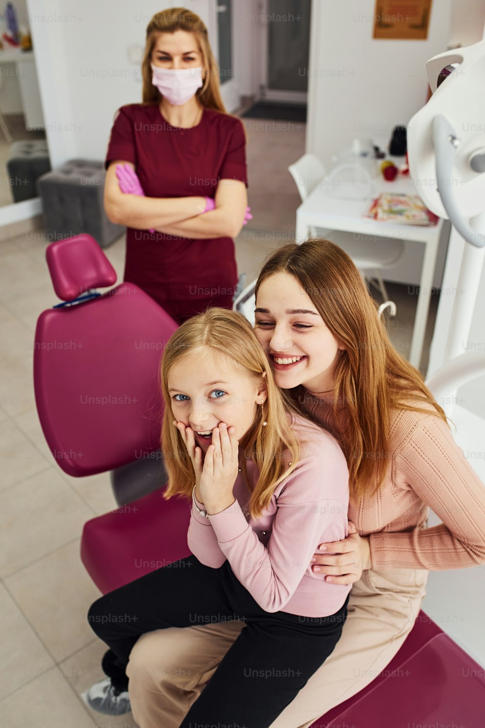 Kleines Mädchen besucht Zahnarzt in der Klinik mit ihrer Mutter. Konzeption der Stomatologie.