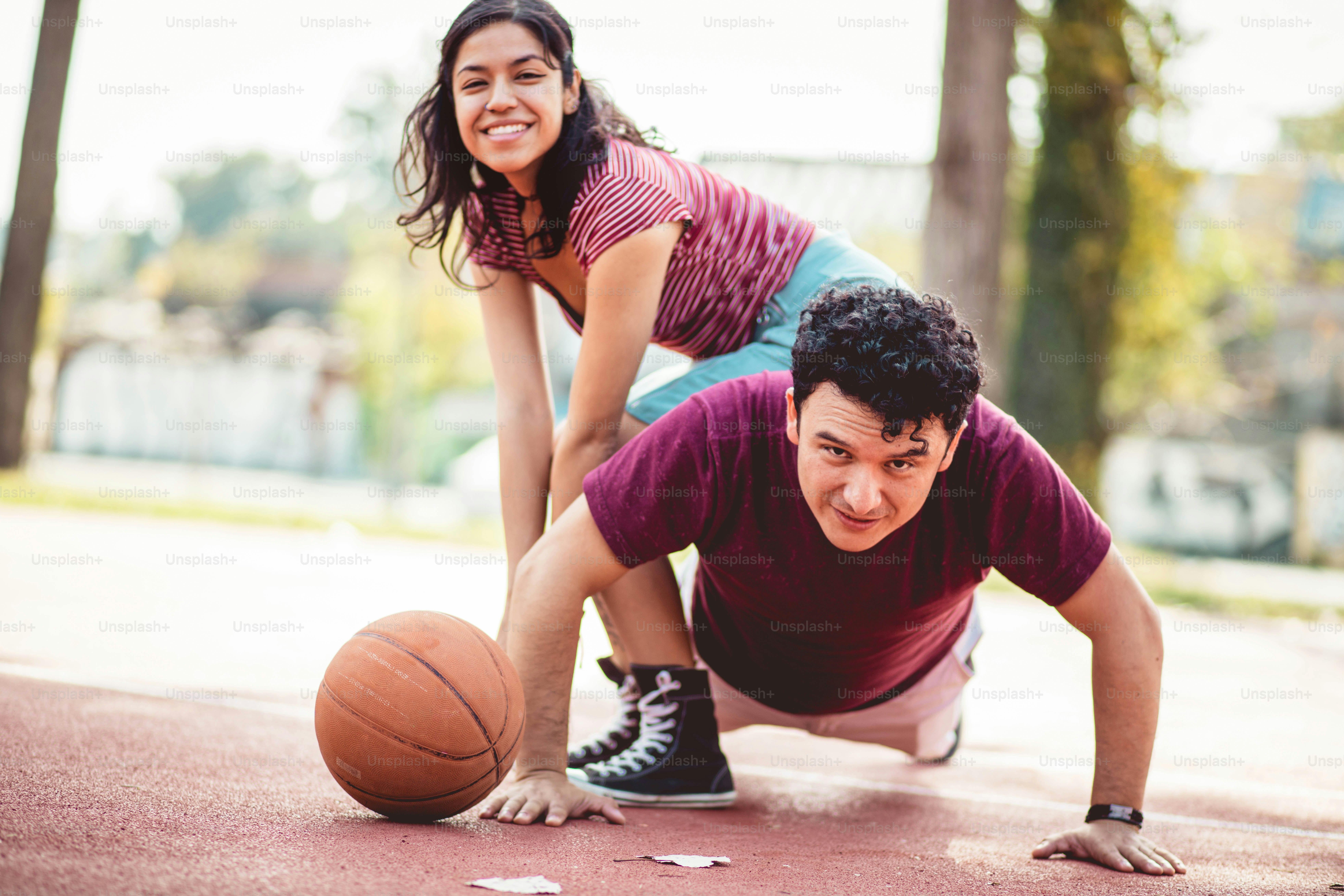 Couple sur un terrain de basket. Homme travaillant des pompes.