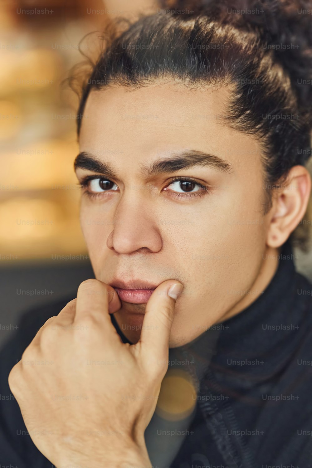 Portrait of confident young man in black sweater that sitting indoors.