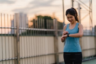 아름 다운 젊은 아시아 운동 선수 아가씨는 도시 환경에서 스트레칭 운동을합니다. 이른 아침에 보도 다리에서 운동복을 입은 일본 십대 소녀. 도시에서 활약 하는 라이프 스타일.