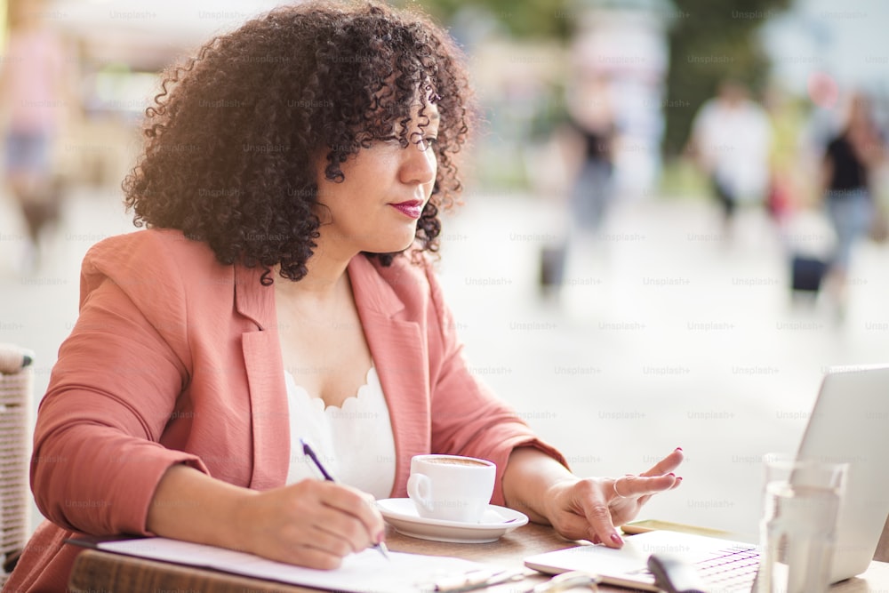 Escritório em café.  Mulher de negócios sentada no café e usando laptop.