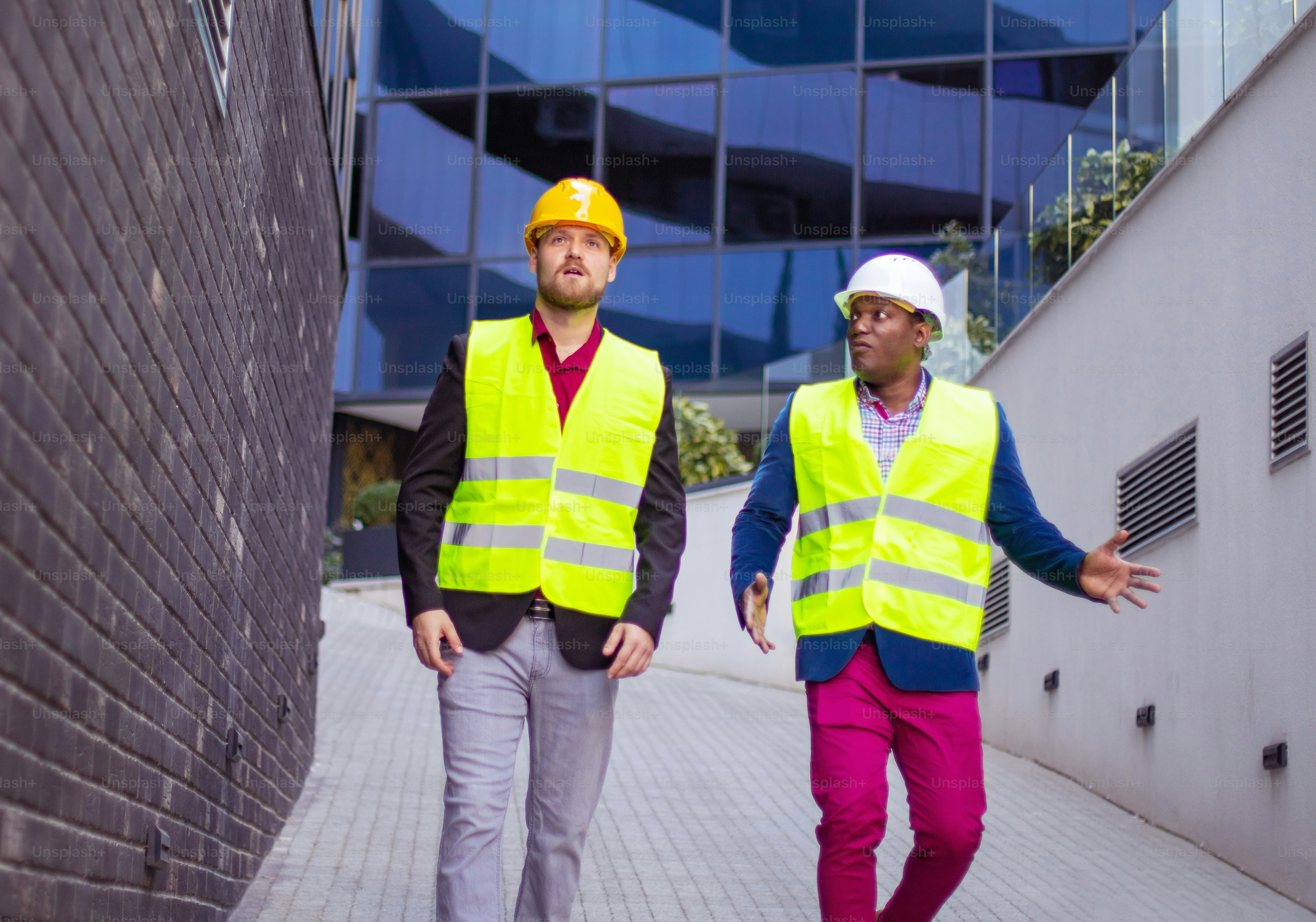 Engineer discussing the structure of the building with architects colleague at construction site. Businessmen talking.