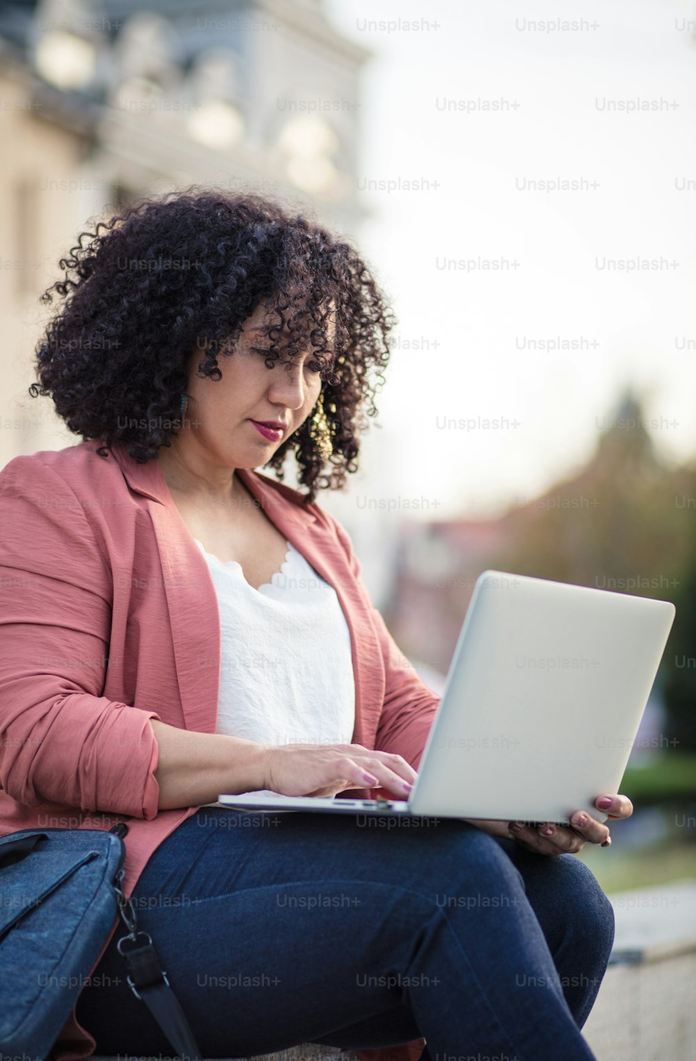Business woman in the street using laptop.