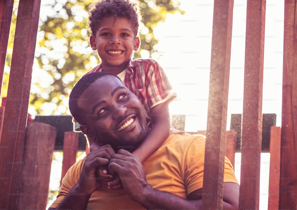African American father and son outside. Portrait of son and dad.