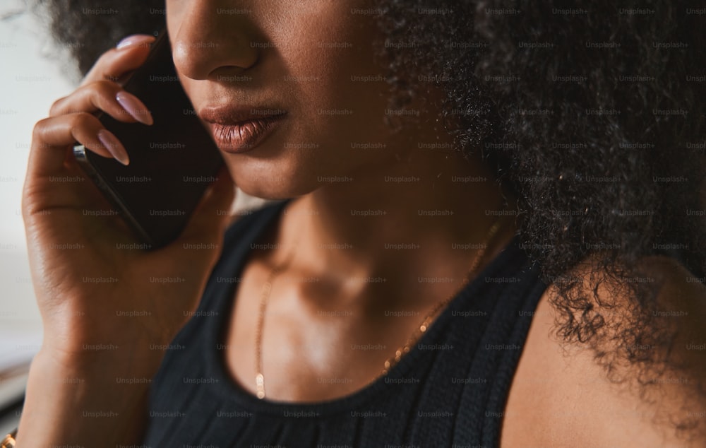 Cropped photo of a serious woman showing no emotions while talking on the phone