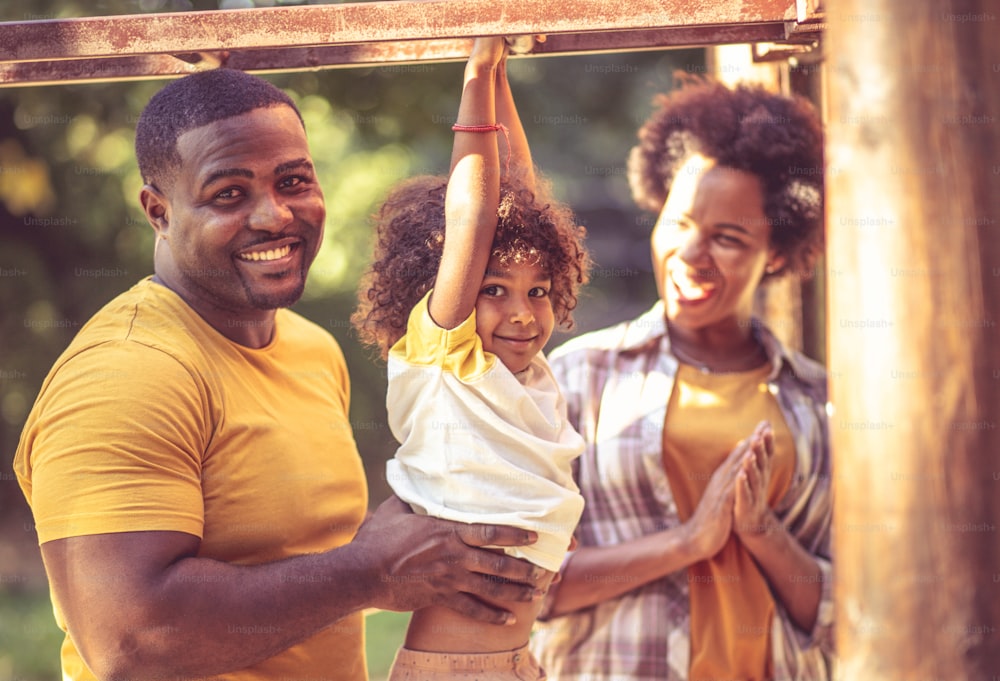 Happy African American family having fun on playground.