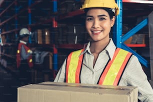 倉庫で微笑む若いアジアの女性倉庫労働者の肖像画。物流、サプライチェーン、倉庫のビジネスコンセプト。