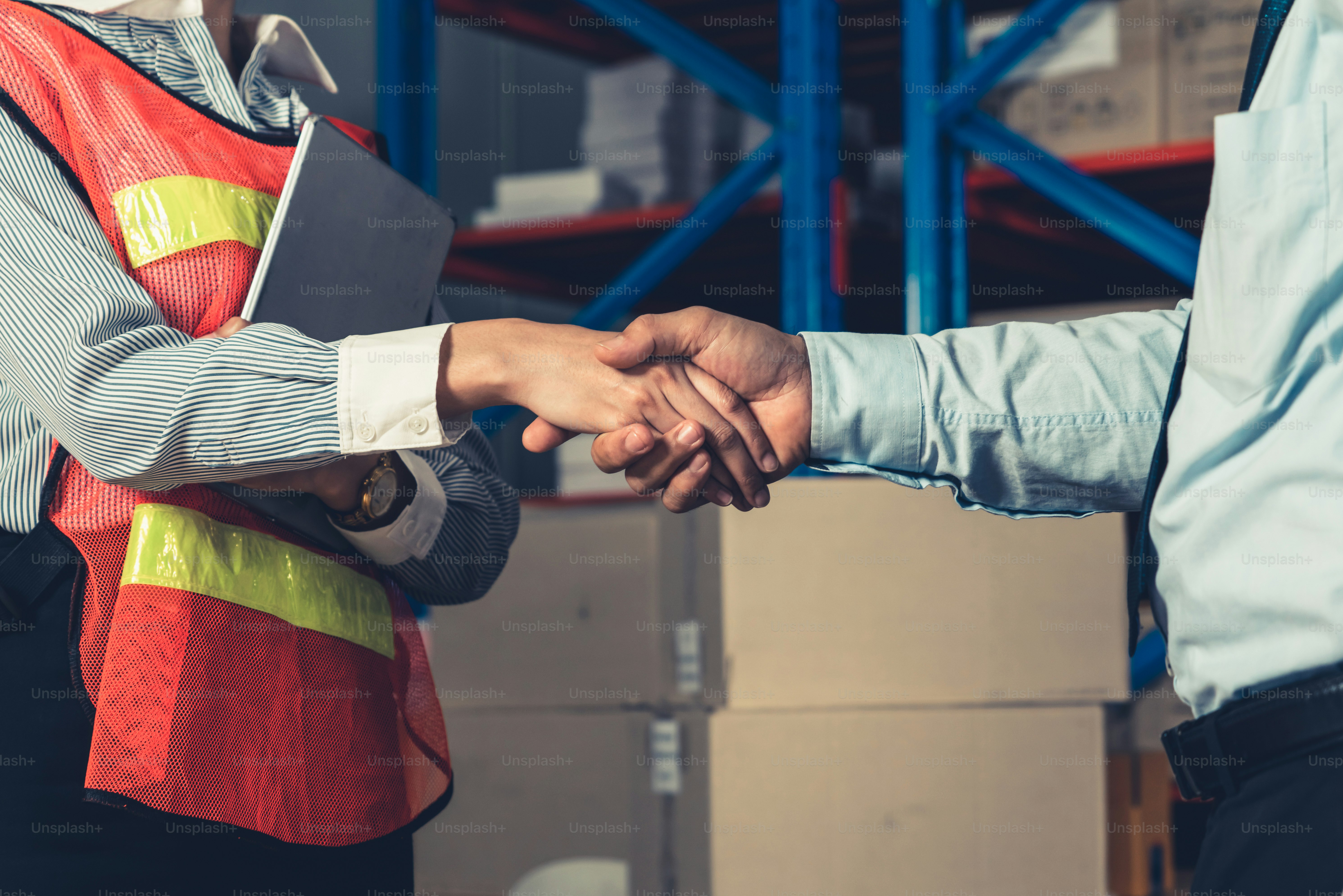 Warehouse worker handshake with manager in storehouse . Logistics , supply chain and warehouse business concept .