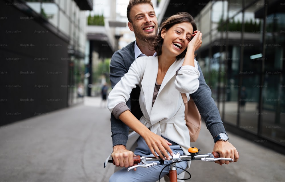 Portrait of happy young couple in love riding a bicycle and having fun together outdoor