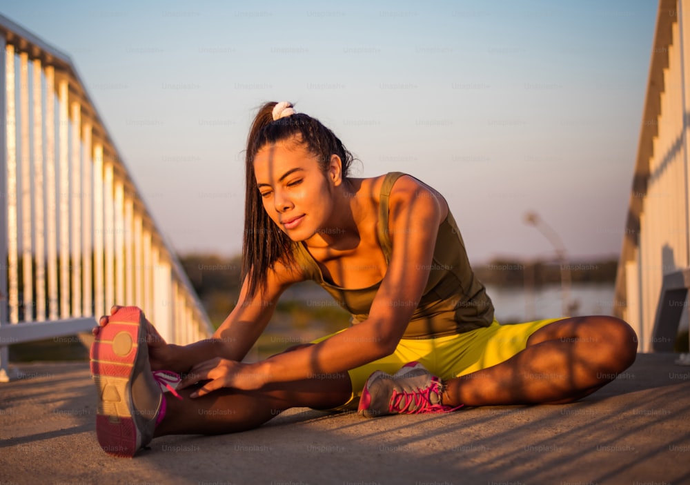 Femme sportive africaine travaillant l’exercice sur le pont. L’athlète s’échauffe avant un entraînement intensif.