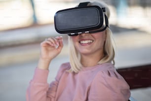 Mondo virtuale. Giovane donna con casco VR. Donna alla stazione degli autobus.