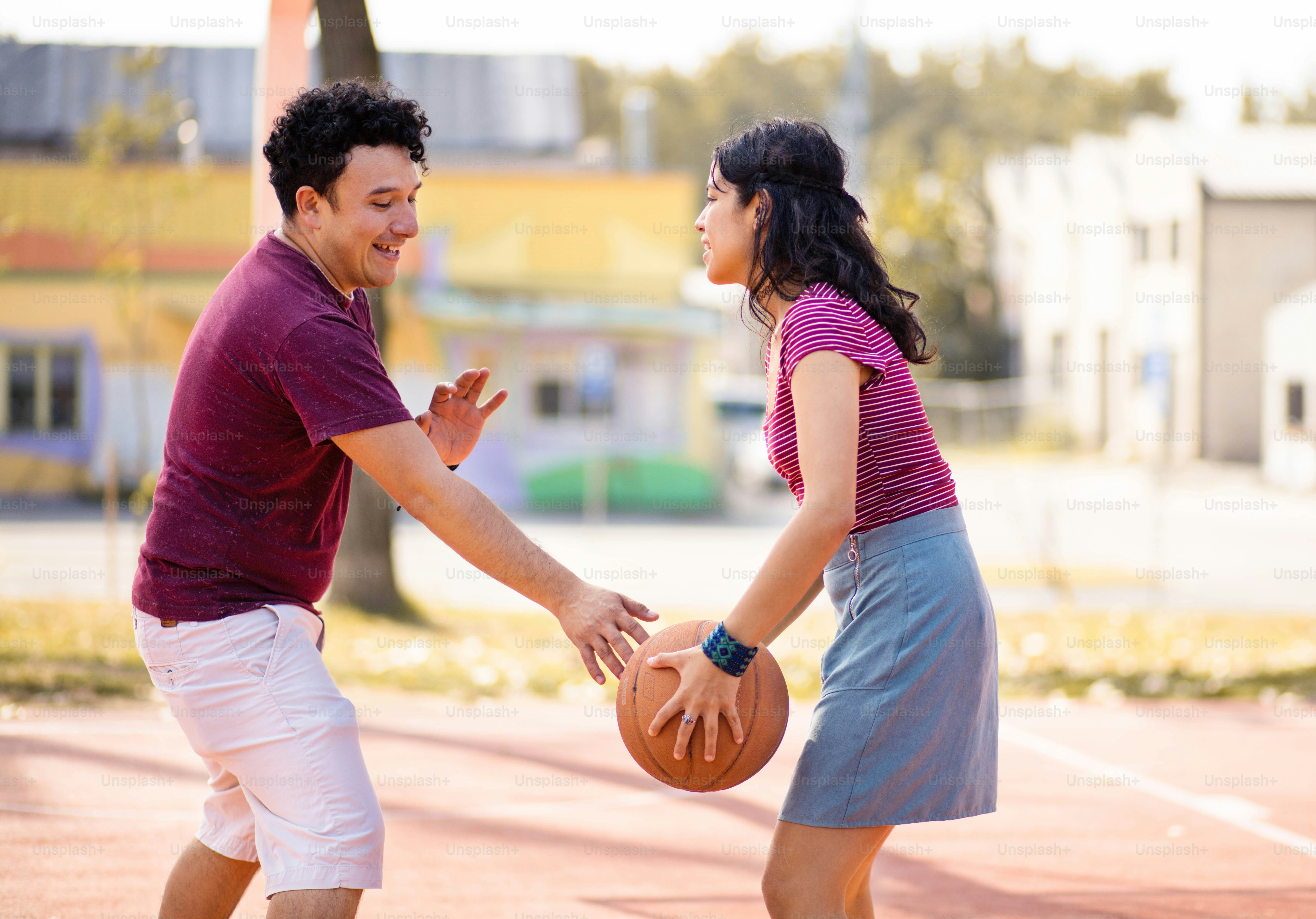 Jeune couple jouant au basket-ball.