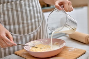 ama de casa cocinando en la cocina de casa. Mano femenina amasando la masa