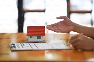 Woman signing a purchase agreement from broker."nReal estate and mortgages.