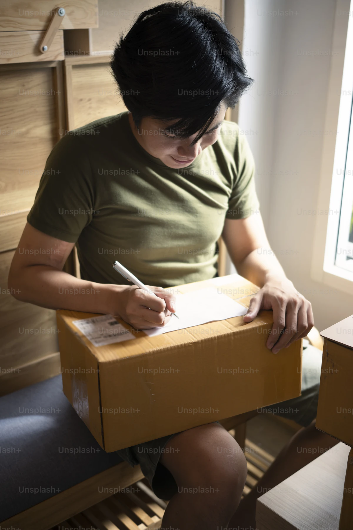 Person labelling a parcel before collection