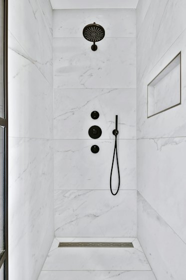Modern marble shower with matte black wall-mounted fixtures