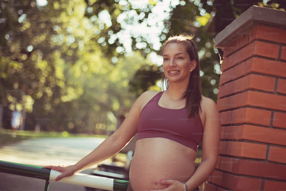 Pregnant woman standing in the park.